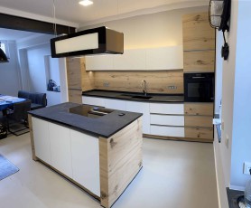 Furnierte Küche mit Kochinsel und Natursteinplatte