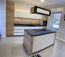 Furnierte Küche mit Kochinsel und Natursteinplatte